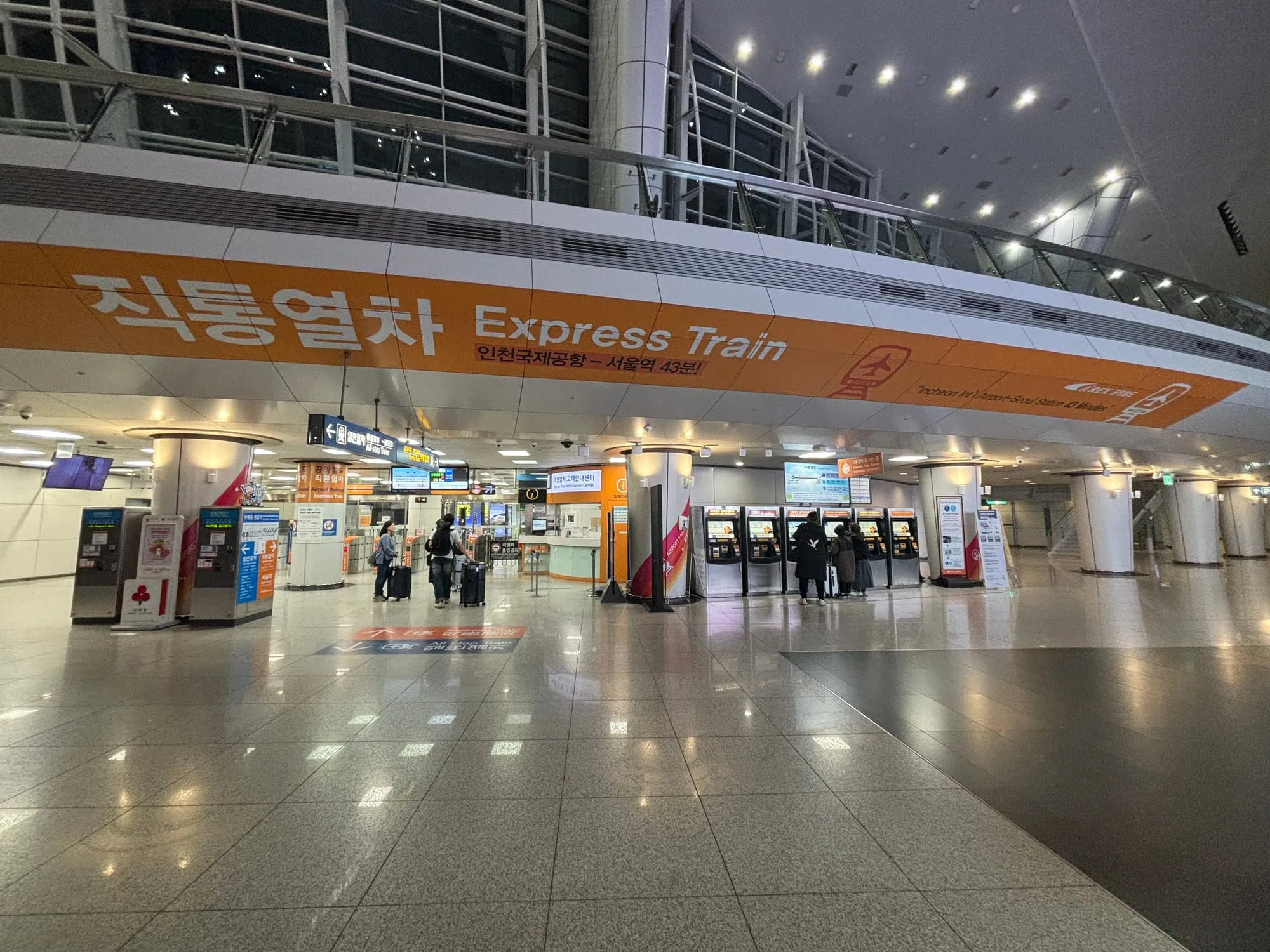 AREX Express train concourse at Incheon International Airport Terminal 1 Station, with signs pointing to the platforms